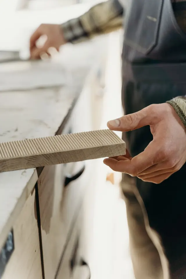 Menuisier ajustant une pièce de bois dans son atelier